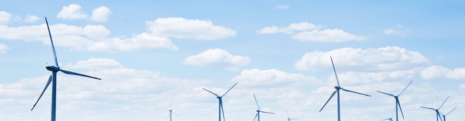 Wind power generation and solar panels against blue sky.