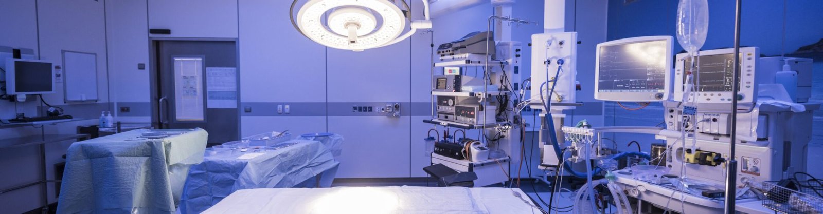 Operating theater with light shining on empty bed. Preparation, absence, organisation, medical equipment.